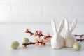Easter spring decorative composition  with white easter ceramic bunny,  pink cherry branch. On a white background Royalty Free Stock Photo