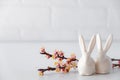 Easter spring decorative composition  with white easter ceramic bunny,  pink cherry branch. On a white background Royalty Free Stock Photo