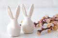 Easter spring decorative composition  with white easter ceramic bunny,  pink cherry branch. On a white background Royalty Free Stock Photo