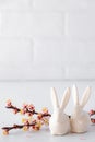 Easter spring decorative composition  with white easter ceramic bunny,  pink cherry branch. On a white background Royalty Free Stock Photo