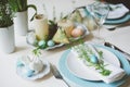 Easter and spring festive table decorated in blue and white tones in natural rustic style, with eggs, bunny, fresh flowers Royalty Free Stock Photo