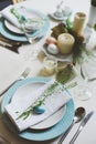 Easter and spring festive table decorated in blue and white tones in natural rustic style, with eggs, bunny, fresh flowers