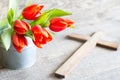 Easter spring red tulips and cross on abstract wooden background