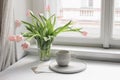 Easter spring still life. cup of coffee and floral bouquet on window sill. Pink tulips flowers in ceramic vase pot Royalty Free Stock Photo