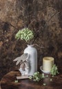 Easter still life - vase with dried hydrangea flowers, candle and  wooden figure of an easter bunny on a wooden table Royalty Free Stock Photo