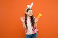 Easter Sunday. child wearing bunny ears. Funny decoration. little girl rabbit hold carrot. collecting and painting eggs Royalty Free Stock Photo