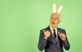 Easter Sunday. Happy businessman advertising product. Bearded man with bunny ears pointing. Presenting product. Product