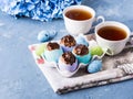 Easter sweet cup cakes treets in colorful egg shells on blue Royalty Free Stock Photo