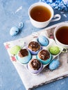 Easter sweet cup cakes treets in colorful egg shells on blue Royalty Free Stock Photo