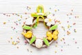 Easter sweet wreath made of bunny and eggs cookies, top view