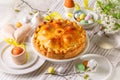 Easter table, with colored eggs, flowers, Savory Easter pie, Torta Pasqualina