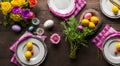 Easter table place setting decoration with colorful eggs. Traditional Easter treats on festive table decorated with spring flowers