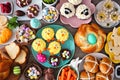 Easter table scene with an assortment of breads, desserts and treats, top view over wood