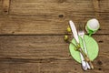 Easter table setting on antique wooden background. Spring holiday card template. Cutlery, crochet napkin, egg, twigs of lilac