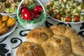 Easter table setting with colored red eggs, bread, green branches decorated, over white plank wooden table with textile Royalty Free Stock Photo