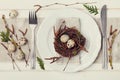 Easter table setting with eggs and spring decoration on rustic background, vintage toning Royalty Free Stock Photo