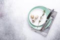 Easter table setting. Empty mint and white plates  linen napkin  eucalyptus leaves and eggs on stone background Royalty Free Stock Photo