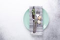 Easter table setting. Empty mint and white plates  linen napkin  eucalyptus leaves and quail eggs on stone background Royalty Free Stock Photo