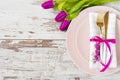 Easter table setting, flatlay ? wedding party, event decoration. Pink dishes and a gold fork and a spoon on a light rustic wooden