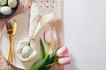 Easter table setting, napkin folded in shape of a rabbit , blue egg and pink tulips