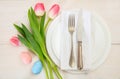 Easter table setting with pink tulips on white wooden background Royalty Free Stock Photo