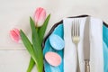 Easter table setting with pink tulips on white wooden background Royalty Free Stock Photo