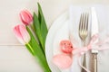 Easter table setting with pink tulips on white wooden background Royalty Free Stock Photo