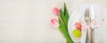 Easter table setting with pink tulips on white wooden background. Top view, copy space, banner