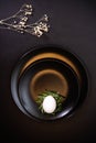 Easter table setting with a white egg in a nest and white flowers on a classic black background Royalty Free Stock Photo