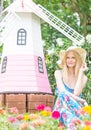 Happy beautiful woman sitting in a flower garden.