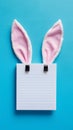 Easter themed notepad with rabbit ears on blue background, top view