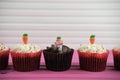 Easter time chocolate cupcakes topped with iced carrots and a miniature person figurine holding a sign indicating i love Easter Royalty Free Stock Photo