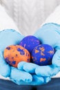 Easter time in quarantine concept. Female hands in blue medical gloves holding colored Easter eggs. Concept of Easter holyday and Royalty Free Stock Photo