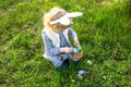 Easter tradition. A girl with a basket collects colorful Easter eggs in the grass. Child wearing bunny ears.