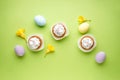 Easter treats, colorful cupcakes on a light green background. Flat lay