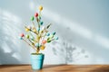 Easter tree decor in blue pot with colorful eggs on the wooden console with light and shadow background. Easter holiday