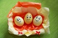 Easter white eggs with painted faces with a smile in a beautiful paper package Royalty Free Stock Photo