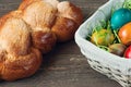 Easter wicker basket with colored eggs and Easter bread on grey wooden board. Royalty Free Stock Photo