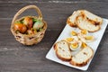 Easter wicker basket with colored eggs and sliced Easter bread in white plate on grey wooden board. Royalty Free Stock Photo