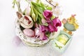 Easter wicker basket with hen figurine and purple tulips