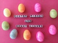 Easter wishes and bunny kisses on a pink background with colorful Easter eggs