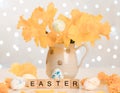 Easter word on wooden cubes. Happy easter. Easter composition of a bouquet of daffodils and Easter eggs