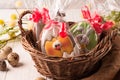 Easter wrapped cookies in a brown wicker basket near quail eggs and blossoming branch