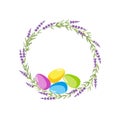 Easter Wreath with copy space. Round frame with lavander plant and bright painted eggs. Colored easter eggs and flowers