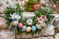 Easter wreath decorating rustic stone wall with eggs and flowers Royalty Free Stock Photo