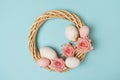 Easter wreath with easter eggs and flowers on blue background Royalty Free Stock Photo
