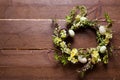 Easter wreath with flowers and eggs on a wooden background. Royalty Free Stock Photo