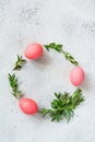 Easter wreath of pine needles, boxwood and painted eggs on light background.