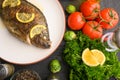 Eastern or European cuisine, Fried fish with fresh vegetables, on a wooden black background. I also eat healthy food. Seafood, Royalty Free Stock Photo