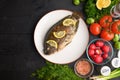 Eastern or European cuisine, Fried fish with fresh vegetables, on a wooden black background. I also eat healthy food. Seafood, Royalty Free Stock Photo